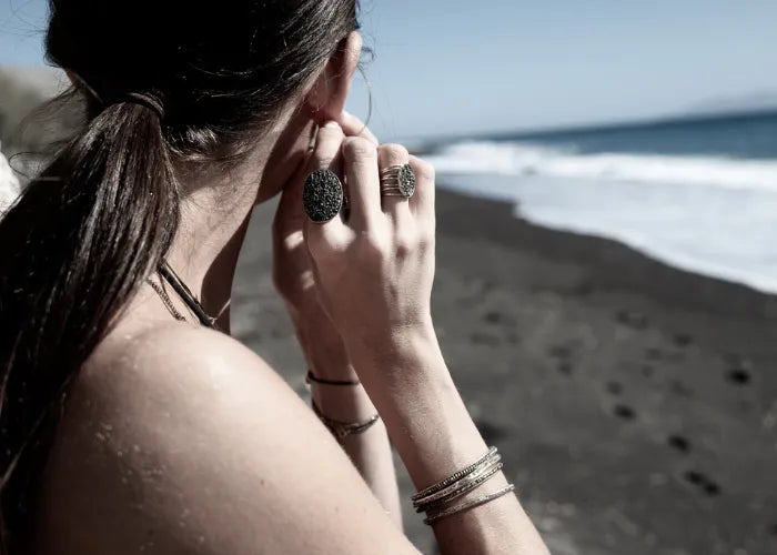 femme sur la plage avec jonc argenté et bagues texturées