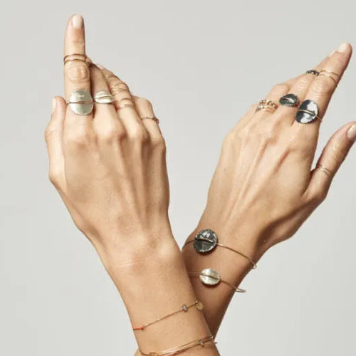 Femme portant la bague Circle avec d’autres bijoux de la collection Sublime.
