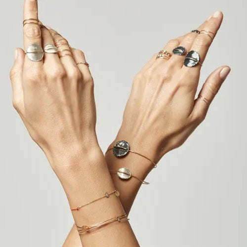 Femme portant une bague fil d’or et plateau argent noir Lsonge