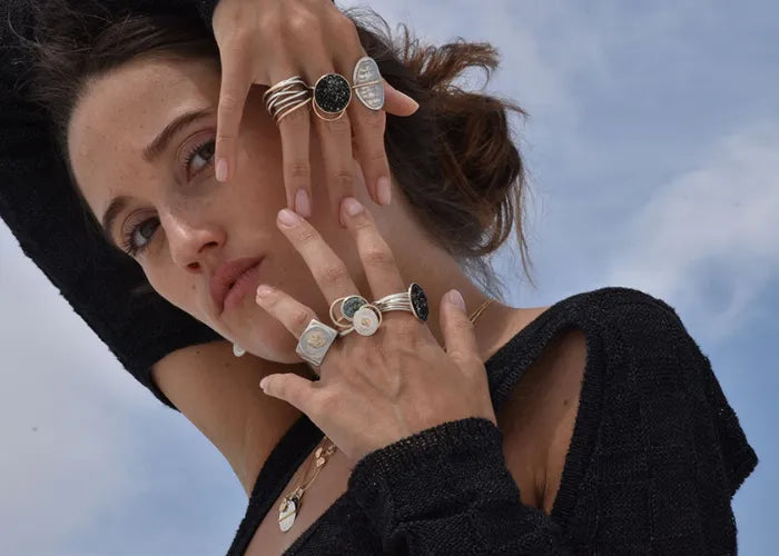 Femme portant la bague Signature Large avec d'autres bagues sur la main