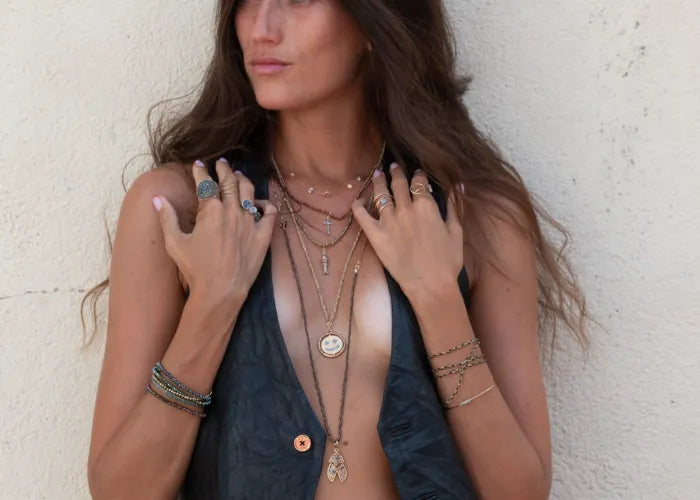 Collier Éclat GM Lsonge porté avec d’autres bagues dorées sur peau bronzée.