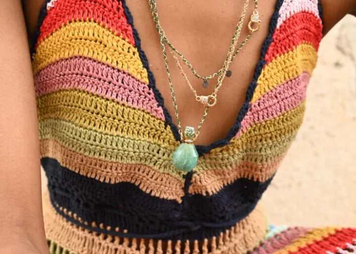 Collier fiole porté avec top coloré – gros plan poitrine