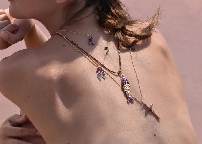 Collier croix XL porté en accumulation avec d’autres colliers dorés – Lsonge