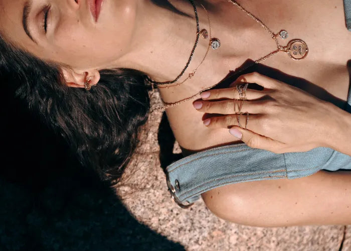 Gros plan sur une femme portant un collier double Smile, version happy et sad en émail diamanté, bijou expressif et moderne.